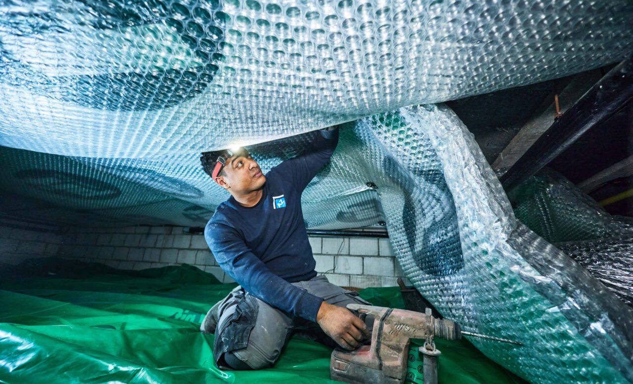 Verwerker verwerkt PIF isolatie onder vloer